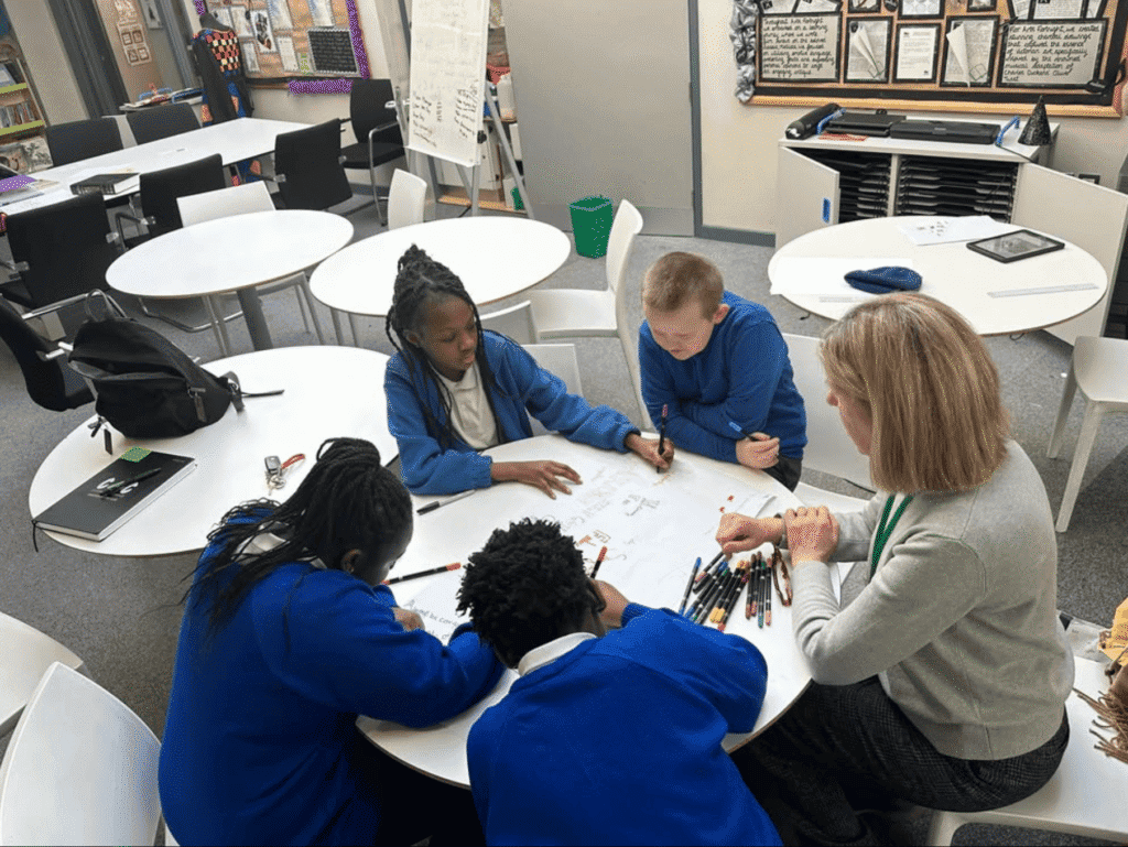 Students collaborating with teacher in a classroom setting for C4CWB program.