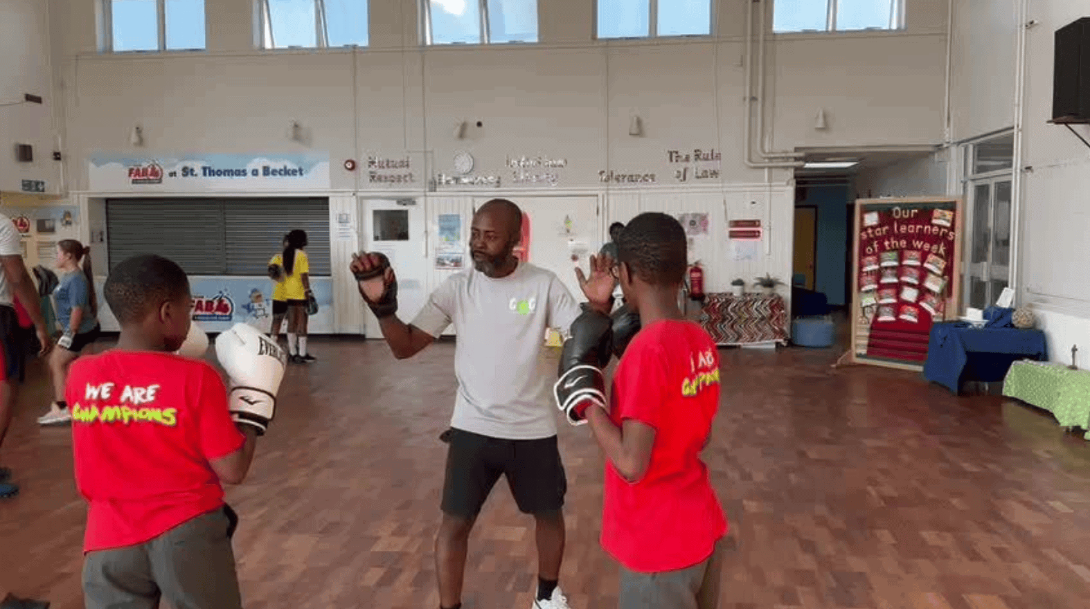 A training session at C4CWB with a coach teaching boxing techniques to young athletes.