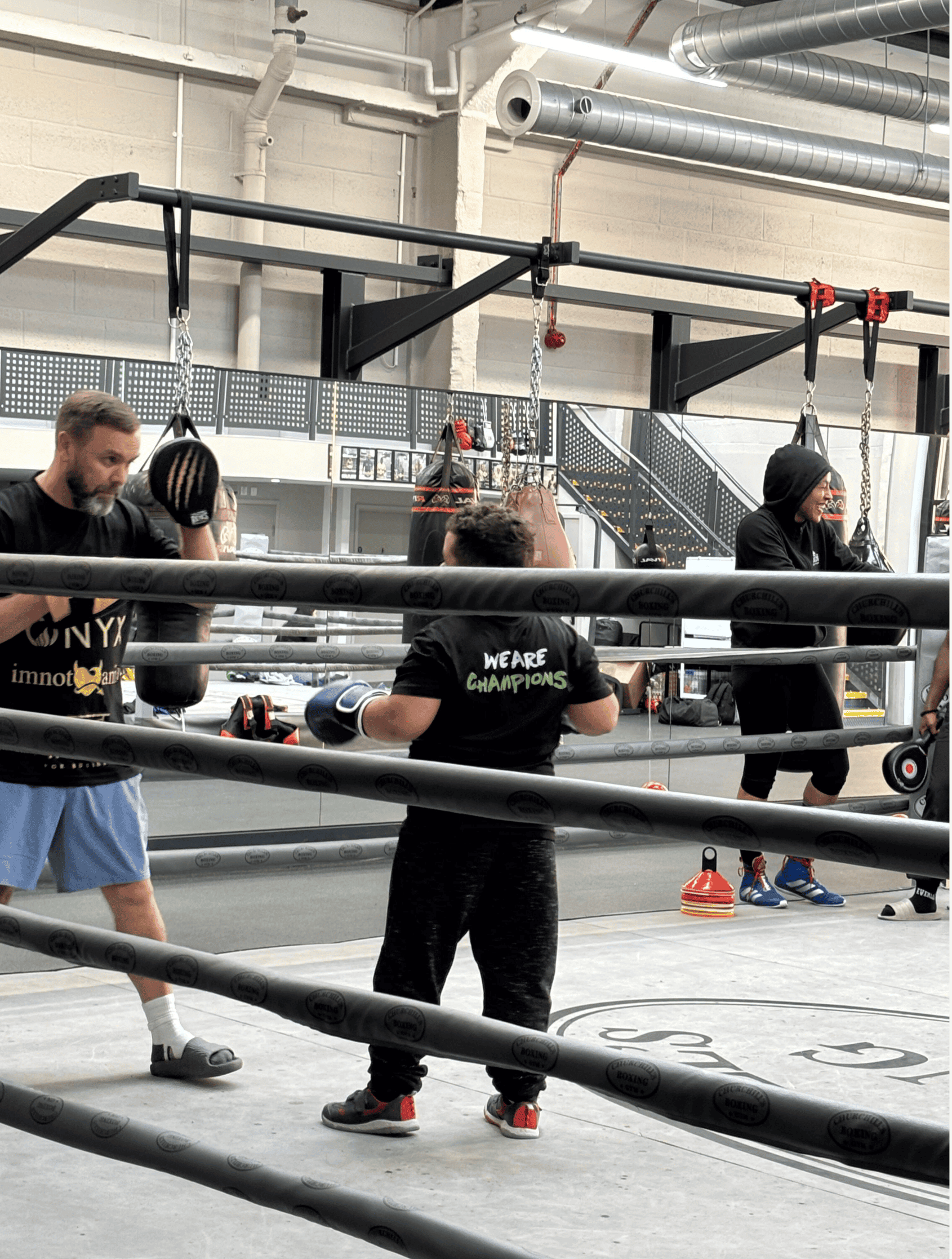 Jump rope training session at C4CWB boxing gym with athletes and coach in a modern, industrial-style.