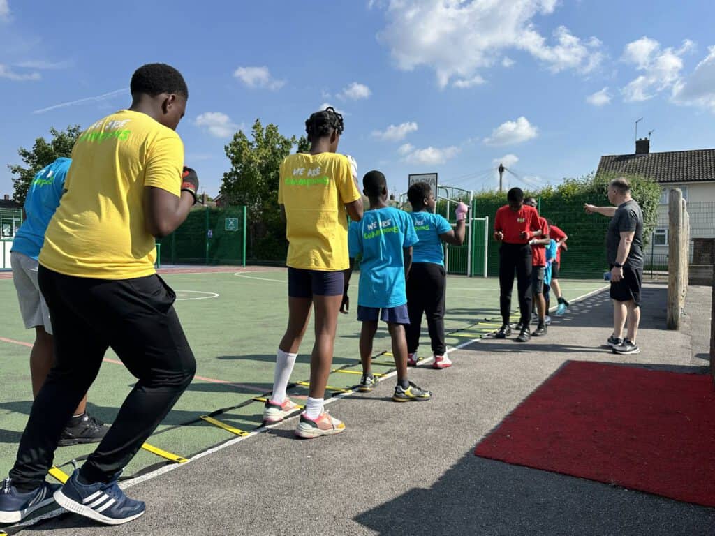 Jump rope training session with diverse children outdoors on a sunny day, promoting fitness and team.
