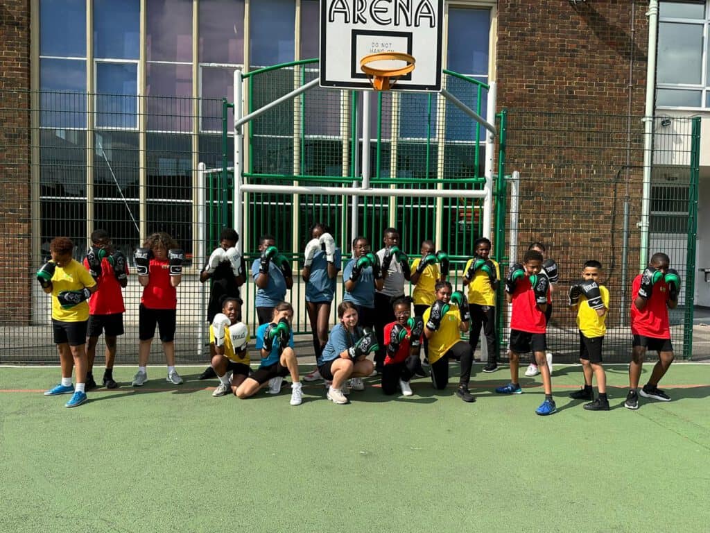 Playing basketball on an outdoor court with children and coaches.
